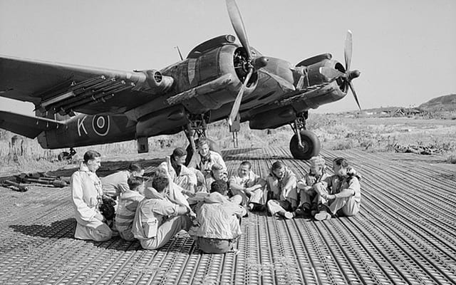 Aircrew of No. 16 Squadron SAAF and No. 227 Squadron RAF sitting in front of a Bristol Beaufighter at Biferno, Italy, prior to taking off to attack a German headquarters building in Dubrovnik, Yugoslavia, 14 August 1944.