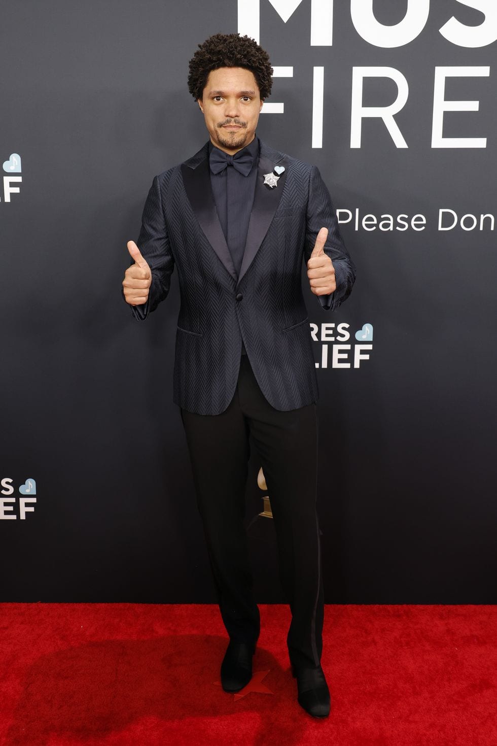 Trevor Noah wearing Giorgio Armani and Tiffany & Co.