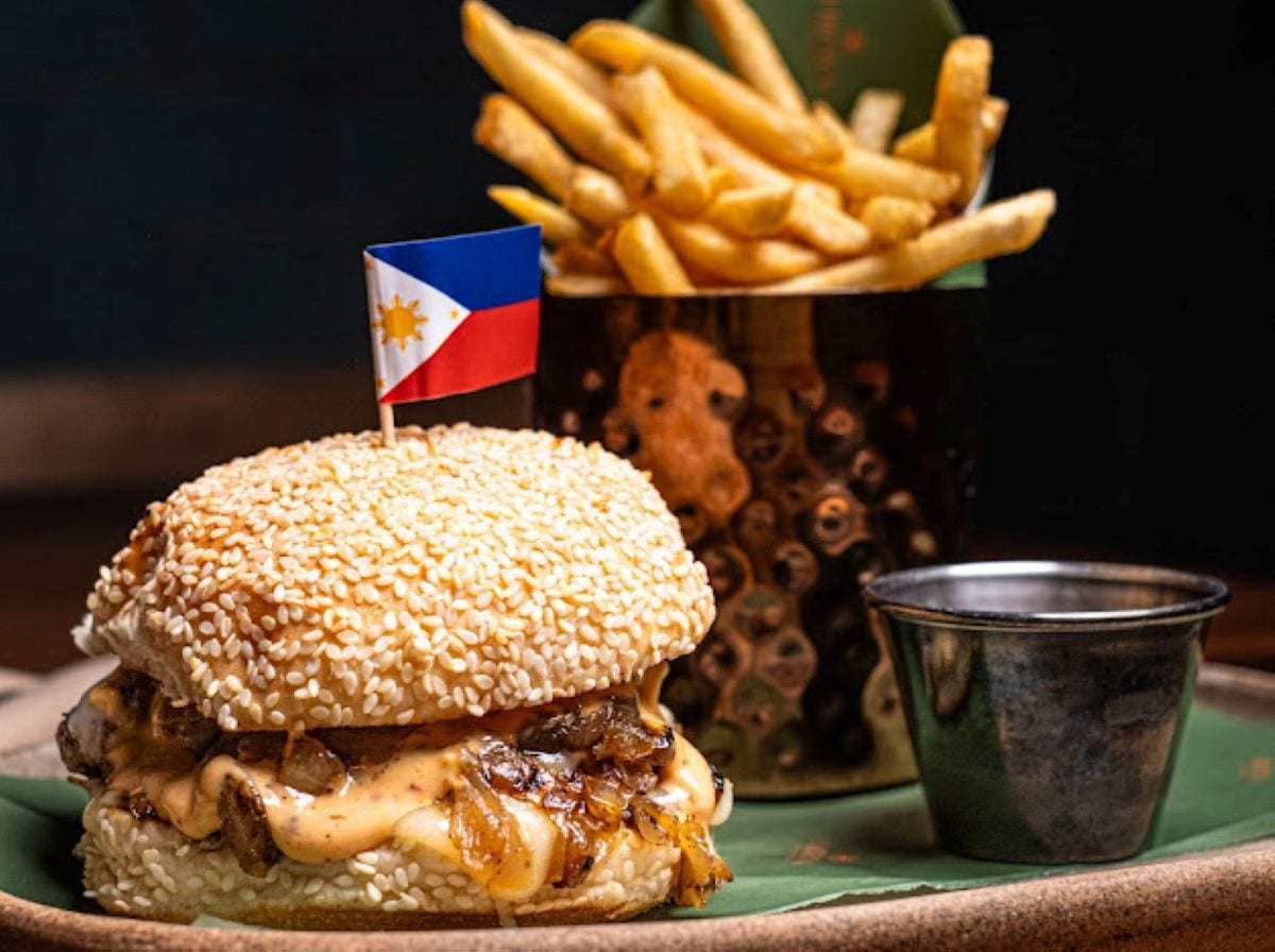HIRAYA CHEEZE BURGER WITH ADOBO CARAMELIZED ONIONS, CHEDDAR AND SESAME BUN.